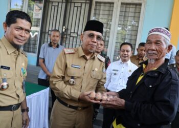 Sekretaris Daerah Kota Pontianak Amirullah menyerahkan secara 1 pak telur kepada Saripin (81), warga Pontianak Tenggara yang berbelanja di Operasi Pasar Murah.