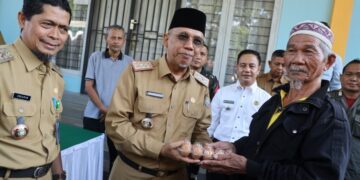 Sekretaris Daerah Kota Pontianak Amirullah menyerahkan secara 1 pak telur kepada Saripin (81), warga Pontianak Tenggara yang berbelanja di Operasi Pasar Murah.