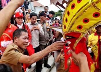 Wakil Bupati Ketapang, Jamhuri Amir menyerahkan angpao kepada naga saat arak-arakan Cap Go Meh, Senin (02/03/2026).(Foto: Prokopim Pemkab Ketapang).
