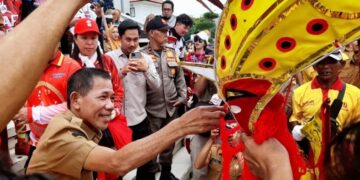 Wakil Bupati Ketapang, Jamhuri Amir menyerahkan angpao kepada naga saat arak-arakan Cap Go Meh, Senin (02/03/2026).(Foto: Prokopim Pemkab Ketapang).