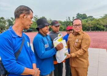Bupati Kubu Raya Sujiwo menyerahkan ratusan paket sembako kepada petugas kebersihan di halaman Kantor Bupati Kubu Raya, Senin (9/3/2026).