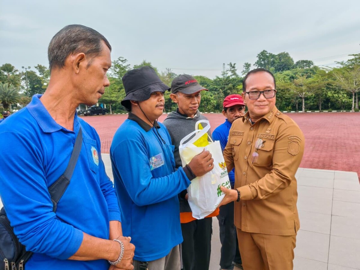 Bupati Kubu Raya Sujiwo menyerahkan ratusan paket sembako kepada petugas kebersihan di halaman Kantor Bupati Kubu Raya, Senin (9/3/2026). 