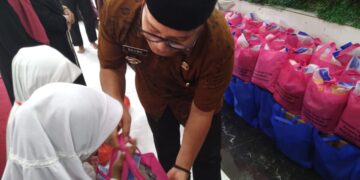 Sujiwo saat menyerahkan santunan di Aula Al-Fityan School Kubu Raya, Desa Pal IX.