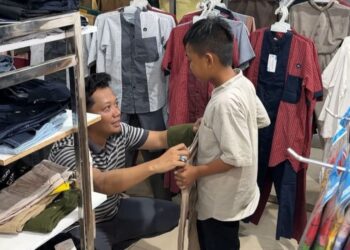 Ketua AJK, Theo Bernadhi ikut memilihkan pakaian untuk salah satu anak yatim. Foto: AJK.