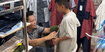 Ketua AJK, Theo Bernadhi ikut memilihkan pakaian untuk salah satu anak yatim. Foto: AJK.