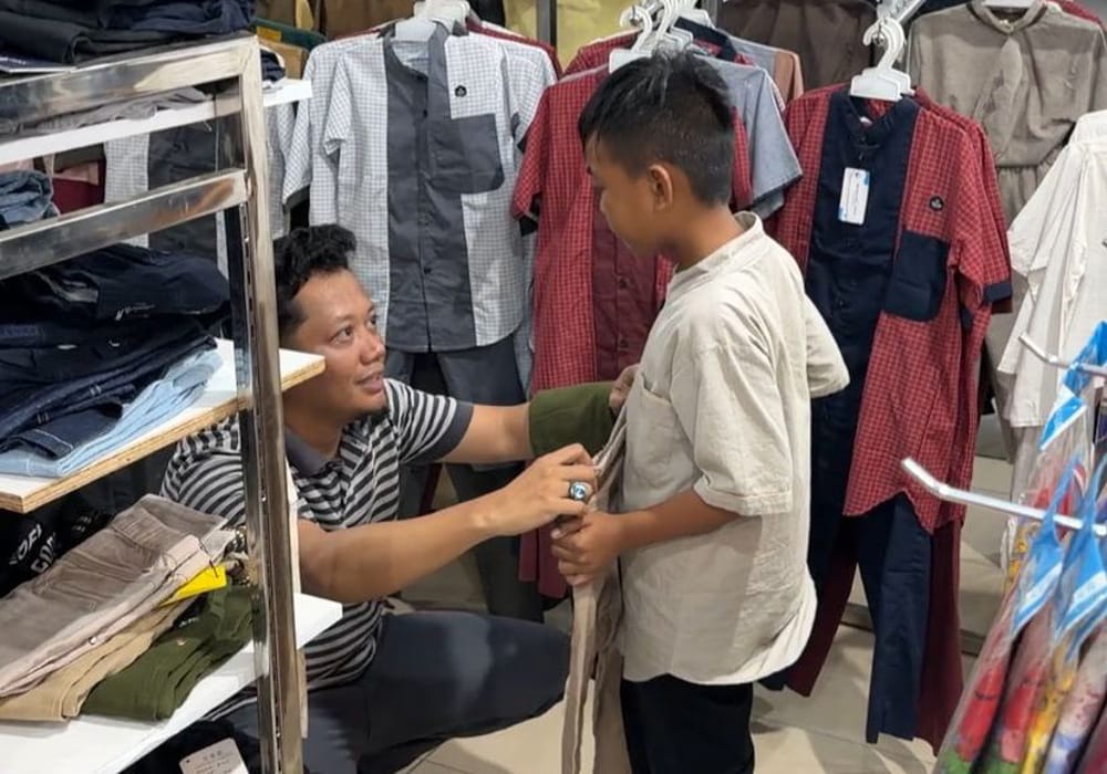 Ketua AJK, Theo Bernadhi ikut memilihkan pakaian untuk salah satu anak yatim. Foto: AJK.