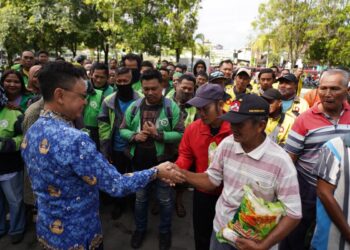 Wali Kota Pontianak Edi Rusdi Kamtono menyerahkan bantuan beras kepada Deris Landuk, penambang sampan tradisional.