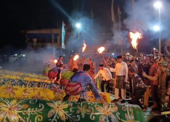 Dentuman keras memecah malam di tepian Sungai Kapuas. Satu per satu meriam karbit disulut, menghadirkan suara menggelegar yang menggema di sepanjang sungai.