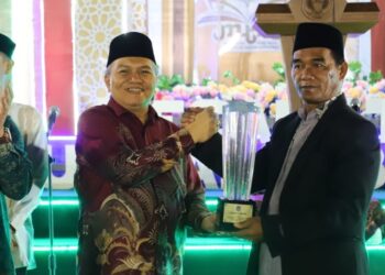 Sekda Yusran Anizam menyerahkan piala kepada Juara Umum MTQ Kubu Raya, Minggu, 19 April 2026, malam.