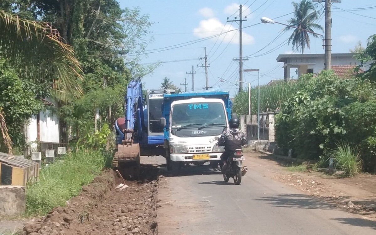 Alat berat mengeruk bahu jalan untuk mempermudah pengecoran. Foto: Probojati Nur Hamzah