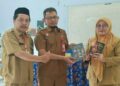Guru SMP Negeri 2 Pakisaji menunjukan buku hasil karya anak didik mereka.