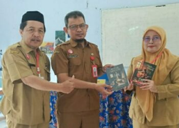 Guru SMP Negeri 2 Pakisaji menunjukan buku hasil karya anak didik mereka.