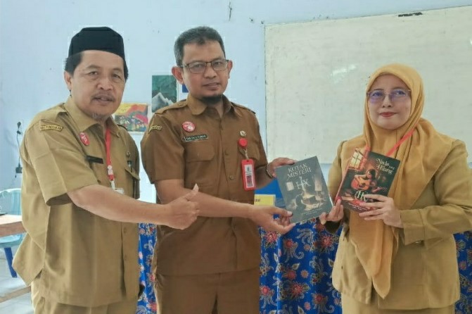 Guru SMP Negeri 2 Pakisaji menunjukan buku hasil karya anak didik mereka.