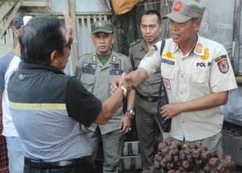 Komandan Regu Tim ITR Jember, Nurhuda, berdialog dengan Ketua LSM Gempar, Anshori, di depan Pasar Sabtuan. Foto Sigit Priyono/Jurnalis.co.id