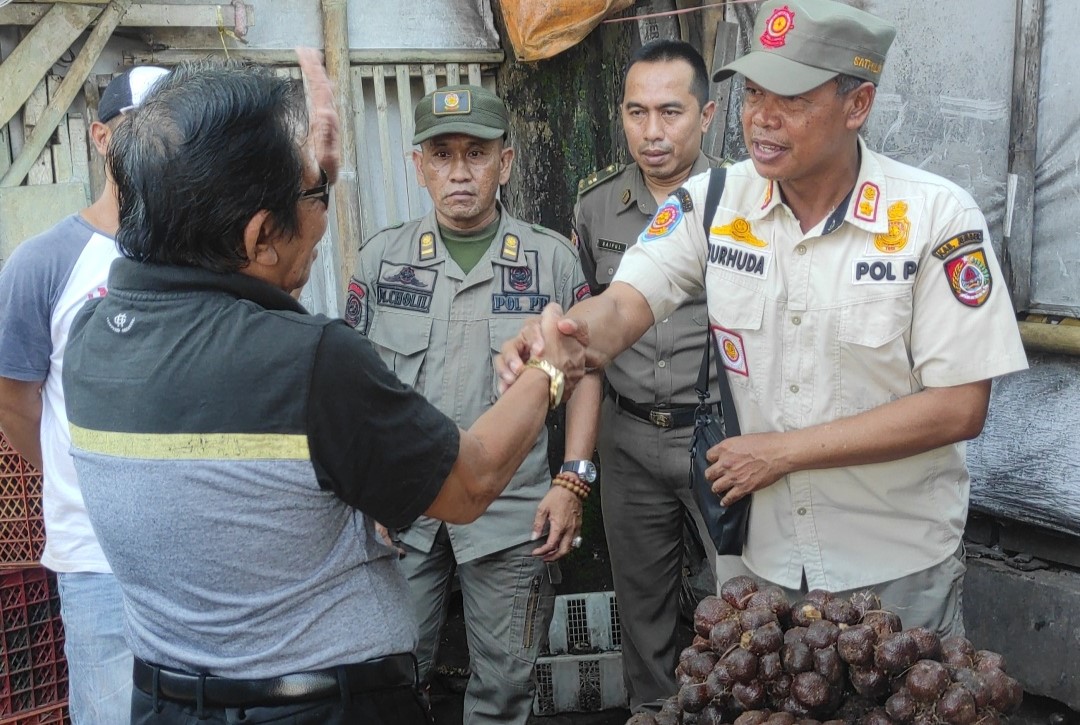 Komandan Regu Tim ITR Jember, Nurhuda, berdialog dengan Ketua LSM Gempar, Anshori, di depan Pasar Sabtuan. Foto Sigit Priyono/Jurnalis.co.id