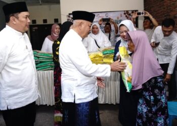 Bupati Sanusi menyerahkan bantuan beras kepada seorang lansia di Kecamatan Pakis, Jumat, 12 Juni 2026 pagi.