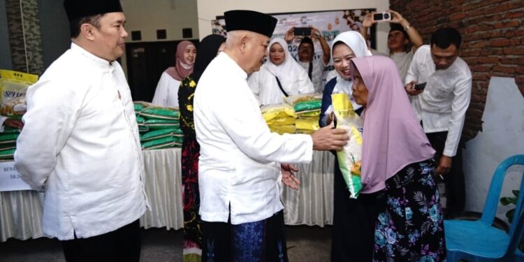 Bupati Sanusi menyerahkan bantuan beras kepada seorang lansia di Kecamatan Pakis, Jumat, 12 Juni 2026 pagi.