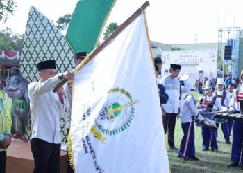 Sekda Replianto mengibarkan bendera sebagai seremoni pelepasan pawai ta'aruf MTQ ingkat Kabupaten Ketapang di Kecamatan Muara Pawan, Sabtu, 13 Juni 2026