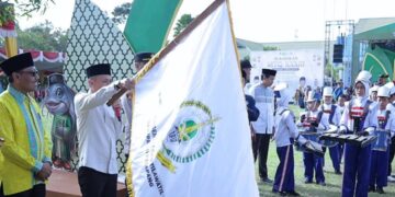 Sekda Replianto mengibarkan bendera sebagai seremoni pelepasan pawai ta'aruf MTQ ingkat Kabupaten Ketapang di Kecamatan Muara Pawan, Sabtu, 13 Juni 2026