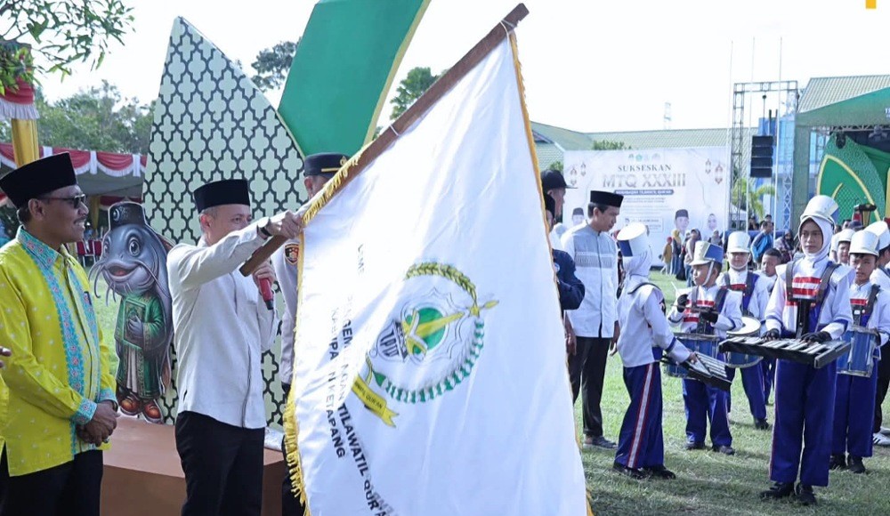Sekda Replianto mengibarkan bendera sebagai seremoni pelepasan pawai ta'aruf MTQ ingkat Kabupaten Ketapang di Kecamatan Muara Pawan, Sabtu, 13 Juni 2026